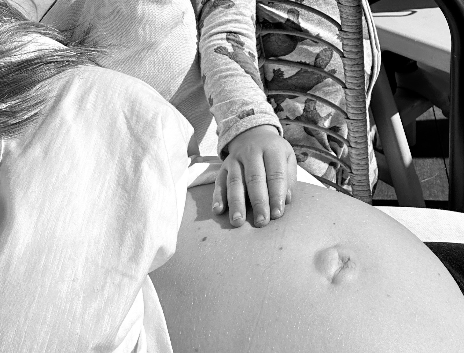A small hand resting on a pregnant belly, representing antenatal feeding preparation